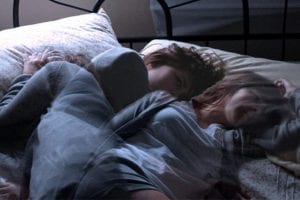 woman tossing and turning in bed