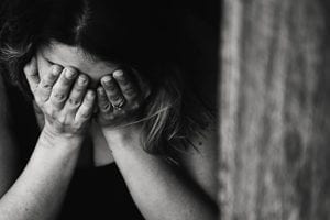 black and white image of woman holding her head in her hands